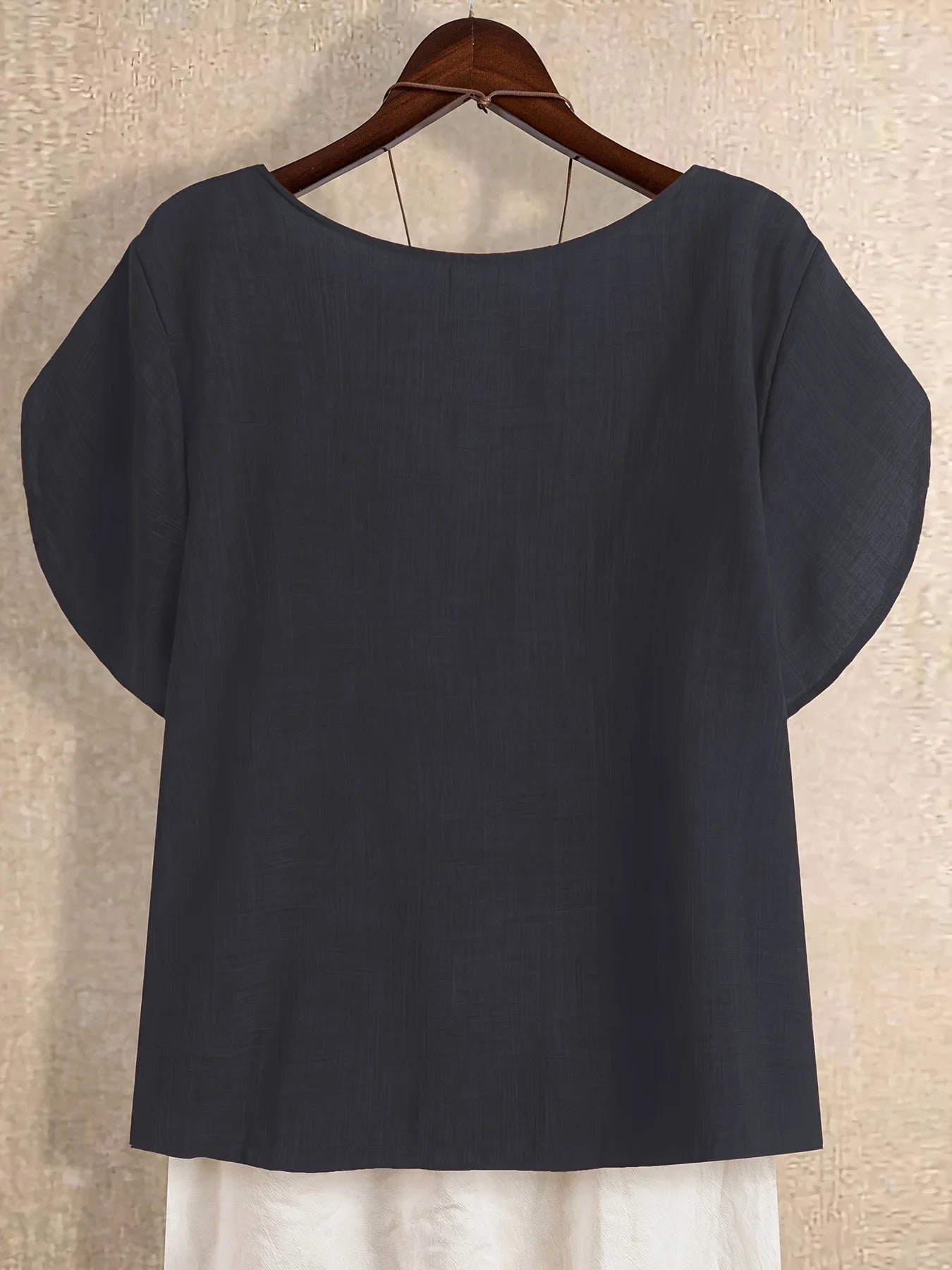 Plus-size women's asymmetrical solid color T-shirt with unique button detail, featuring a comfortable loose fit, suitable for ca
