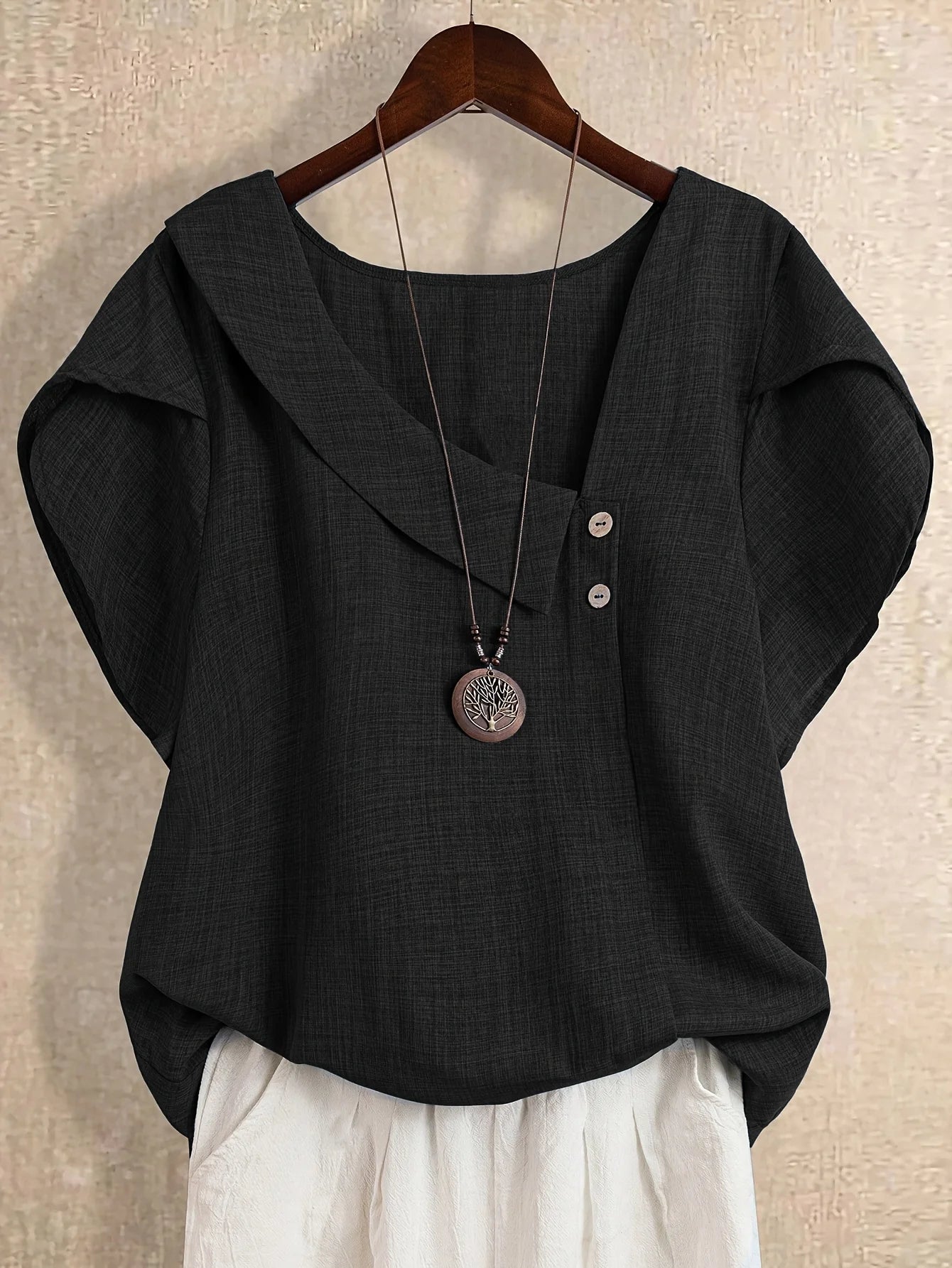 Plus-size women's asymmetrical solid color T-shirt with unique button detail, featuring a comfortable loose fit, suitable for ca